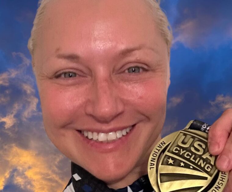 Christine D'Ercole showing one of her medals from the U.S. Masters Track National Championships.