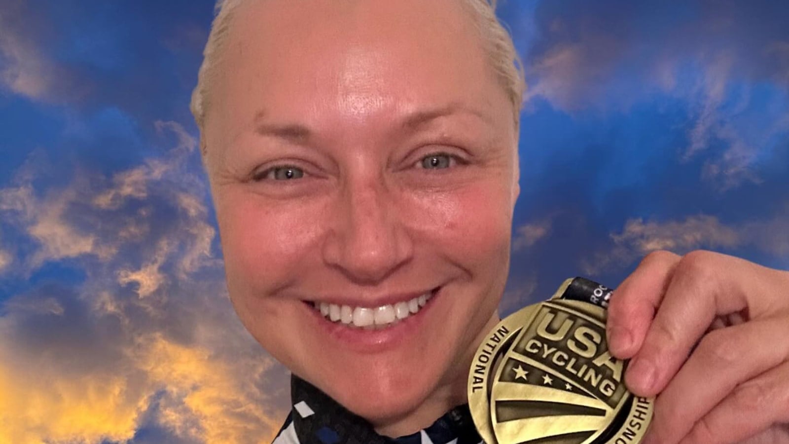 Christine D'Ercole showing one of her medals from the U.S. Masters Track National Championships.