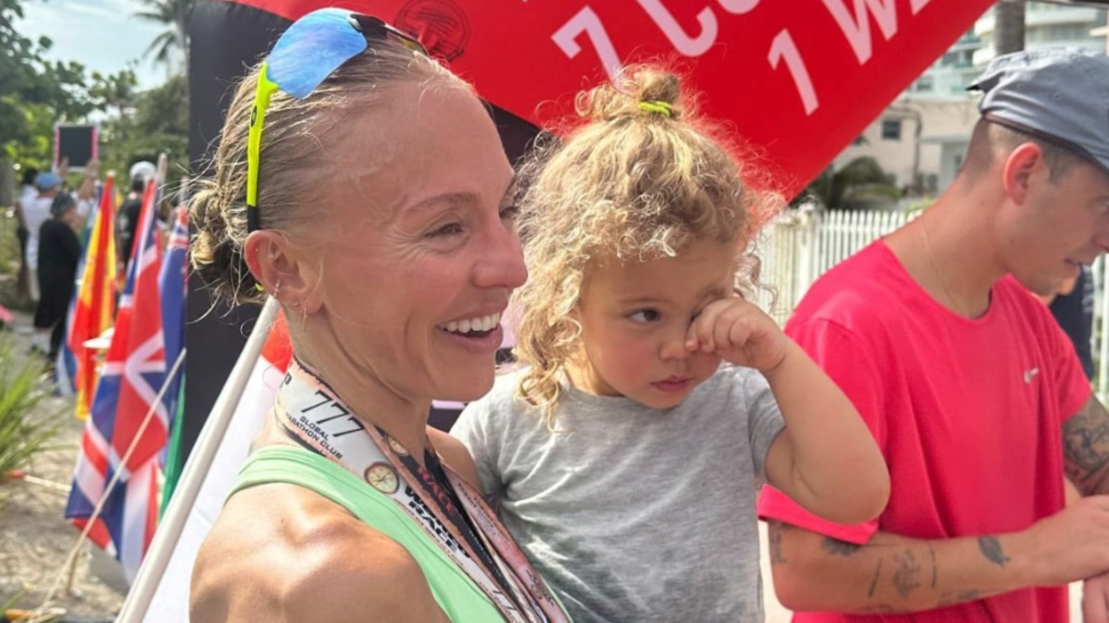 Becs Gentry with her daughter and partner after finishing the final marathon of The Great World Race. Image credit Robin Arzon IG.