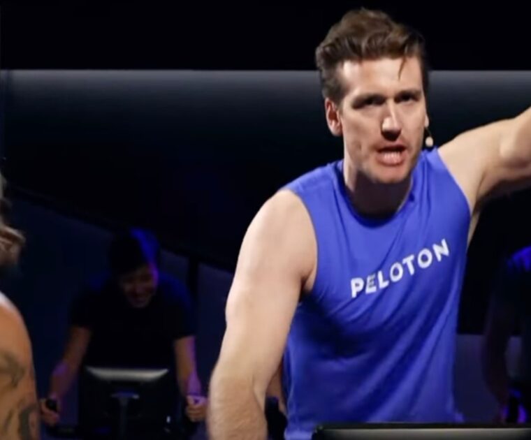 Bradley Rose teaching from member bike in studio.